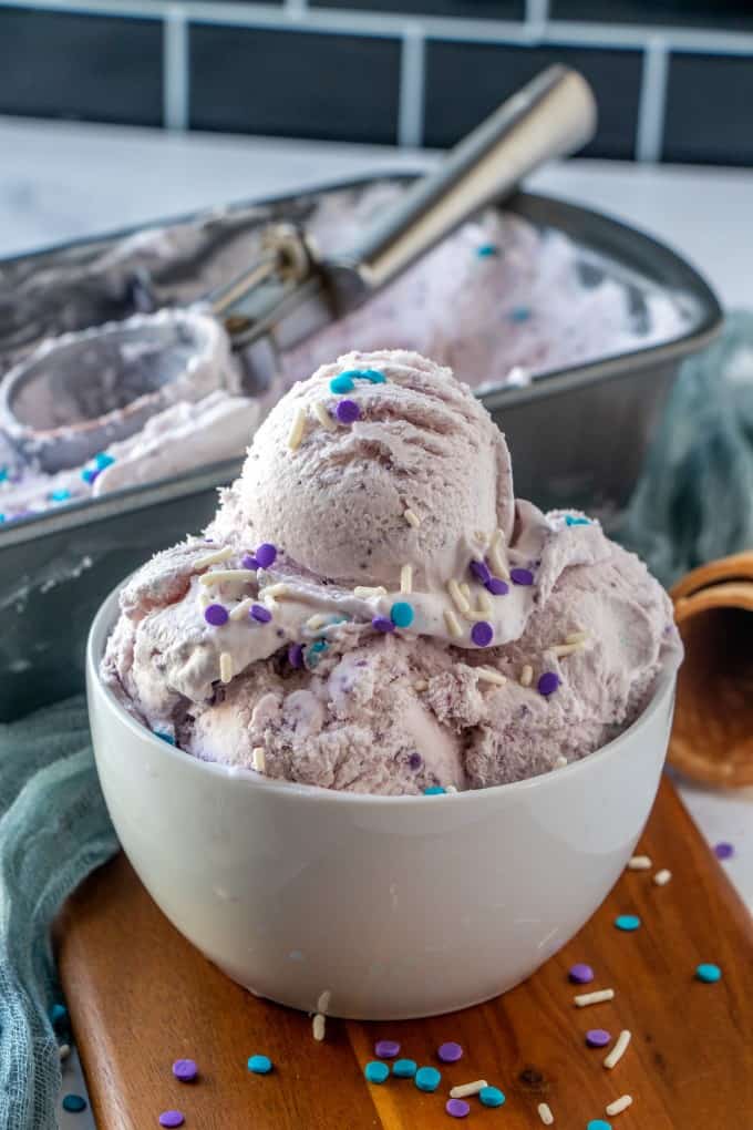 Ube ice cream in a bowl with sprinkles.