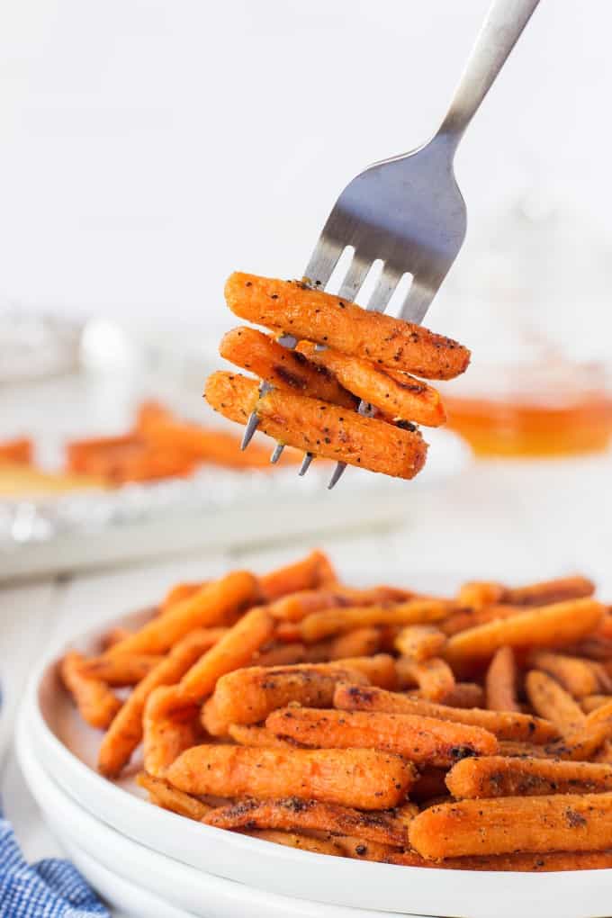 A forkful of carrots from a plate of carrots