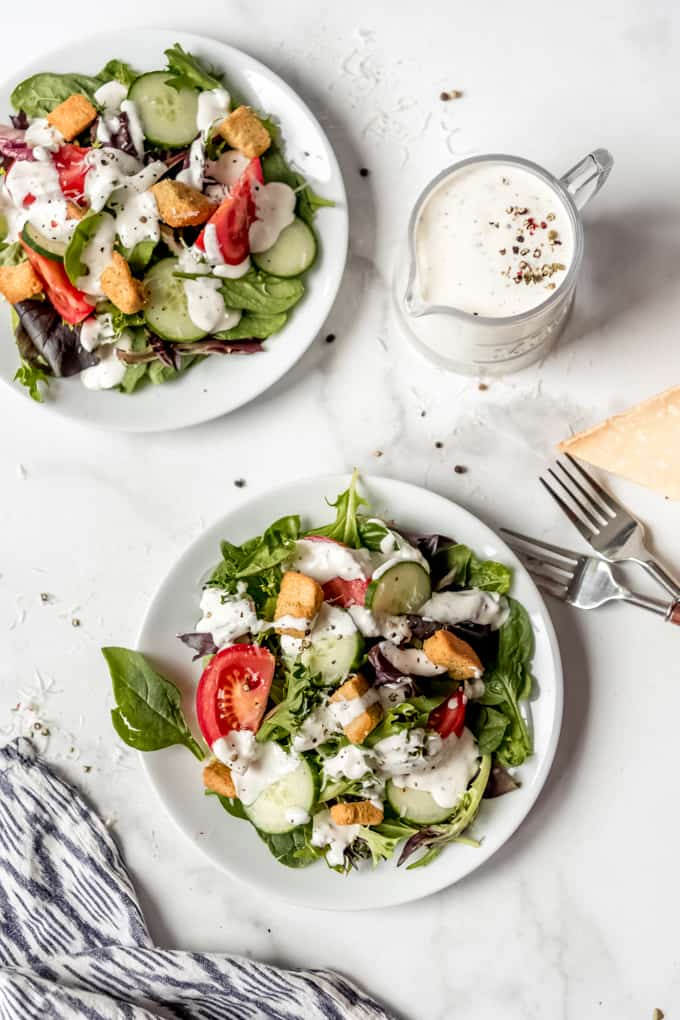 Parmesan peppercorn dressing - A green salad next to a pitcher or parmesan peppercorn dressing.