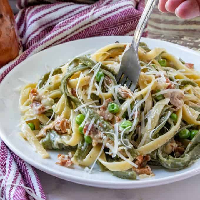 Paglia e Fieno on a white plate with a fork digging in!