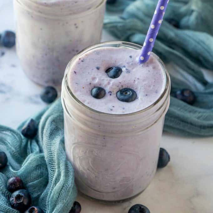 Blueberry Milkshake in a jar with a straw