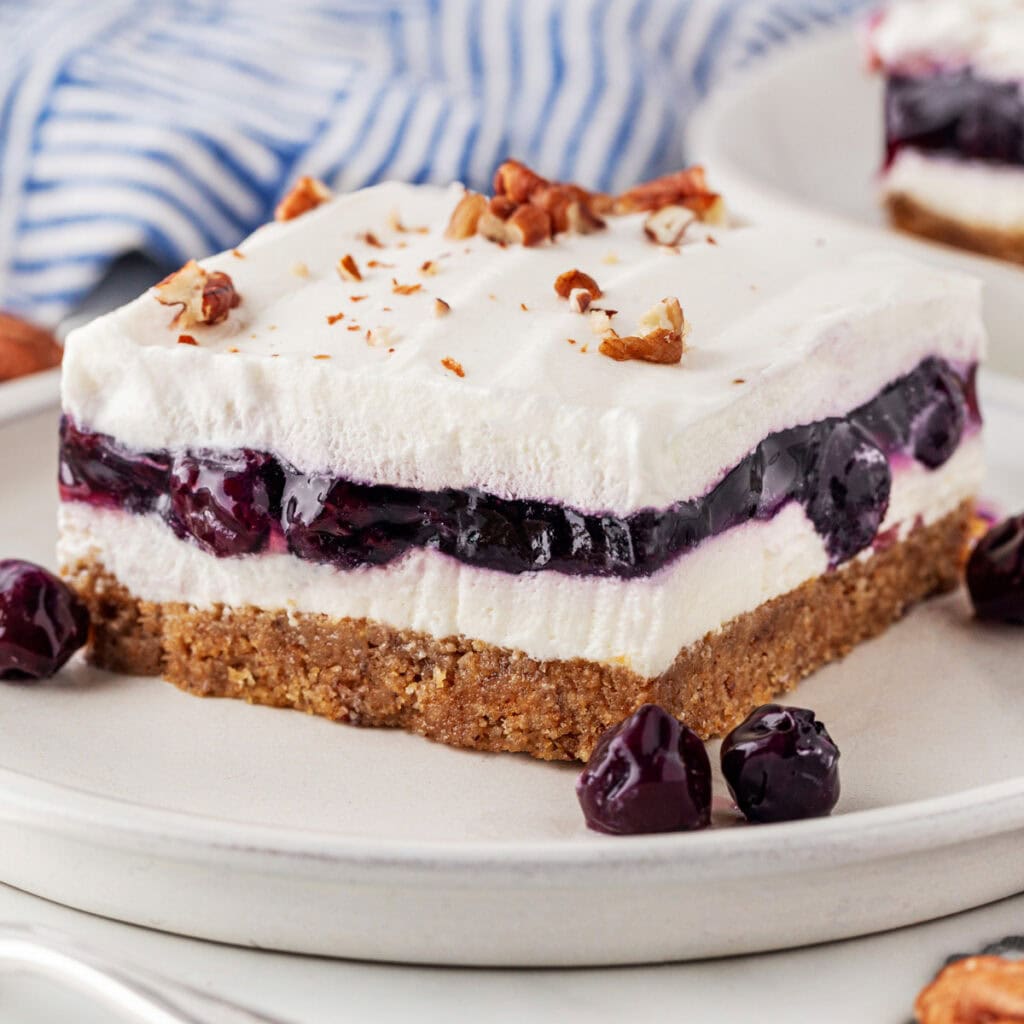 A close-up of a square of blueberry lush on a plate. 