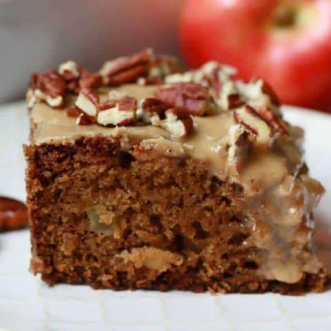 A square of brown Apple Dapple Cake topped with brown butter glaze and chopped pecans.