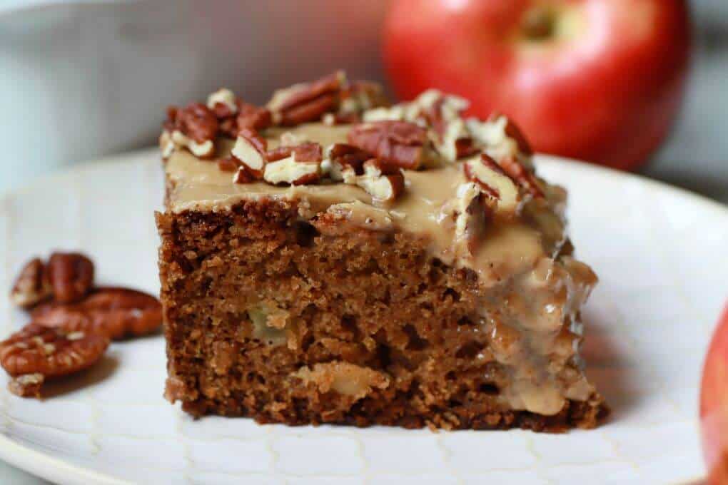 A square of brown Apple Dapple Cake topped with brown butter glaze and chopped pecans.