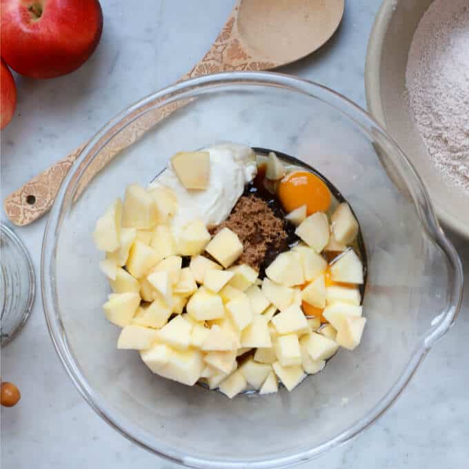 A clear bowl holds ingredients needed to make Apple Dapple Cake.
