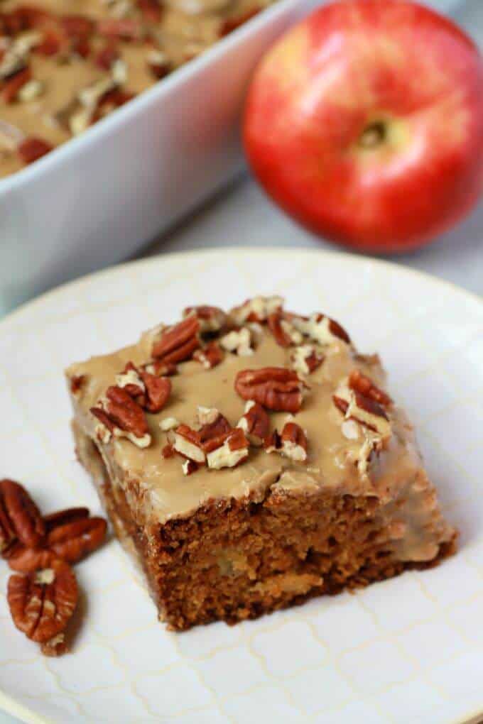 A square of brown Apple Dapple Cake topped with brown butter glaze and chopped pecans.