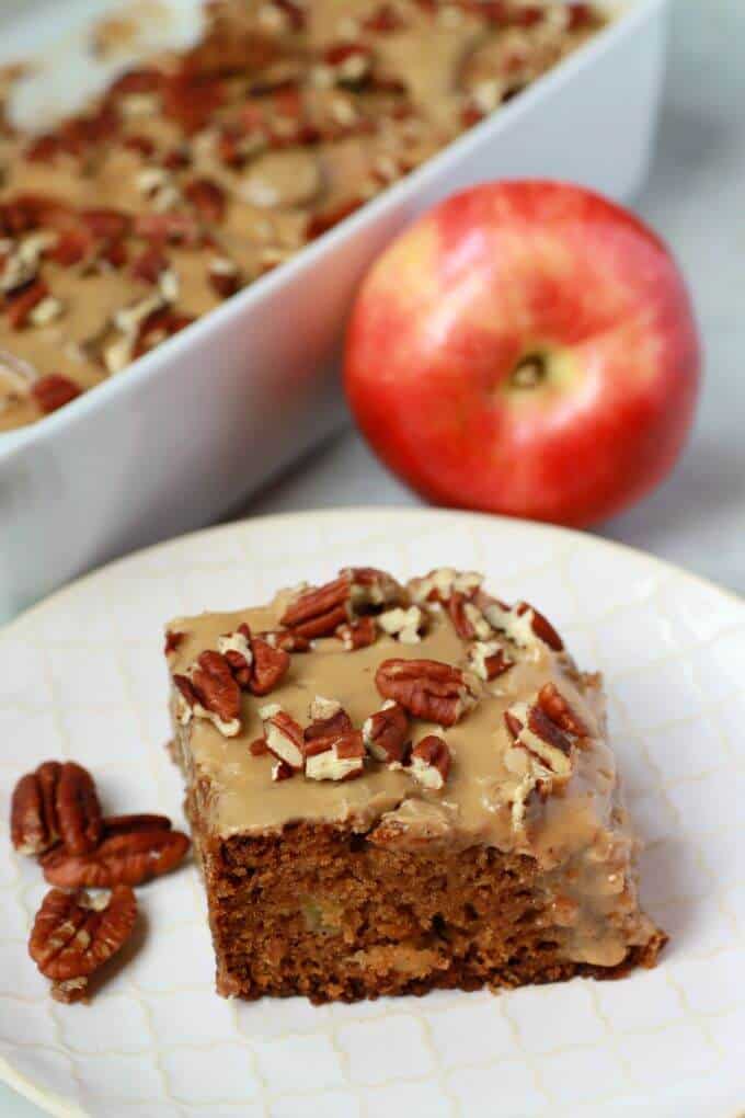 A square of brown Apple Dapple Cake topped with brown butter glaze and chopped pecans.