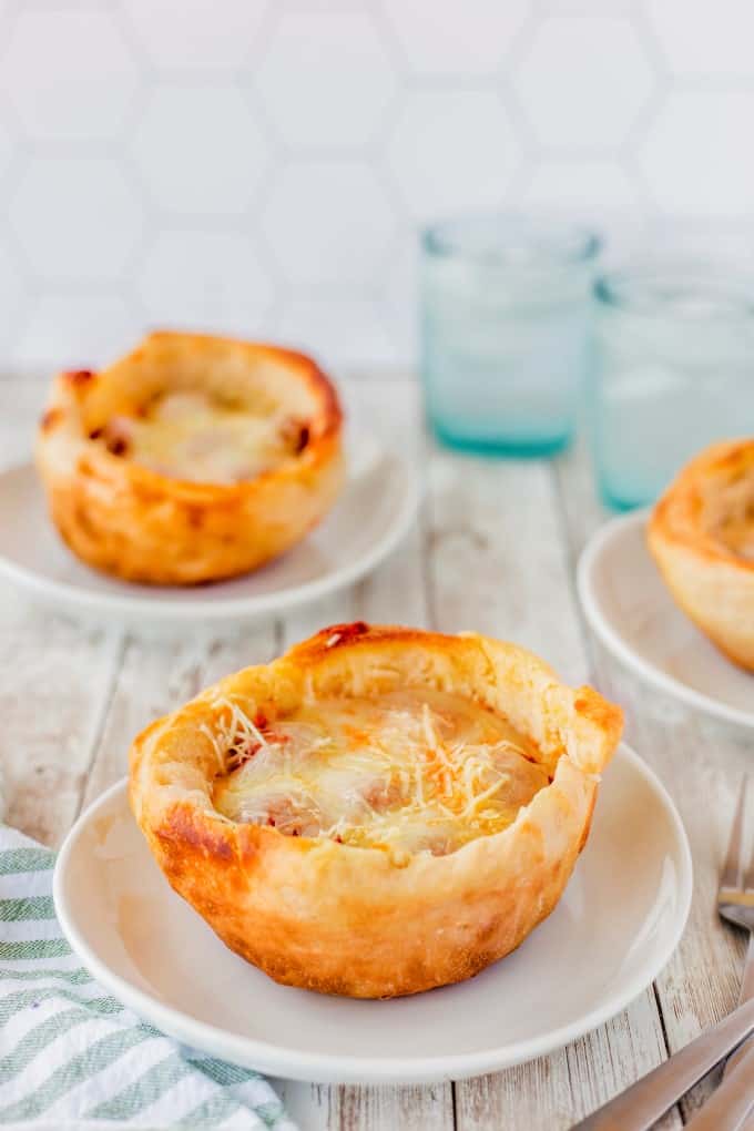 Pizza Bowl on a white plate with others in the back ground.