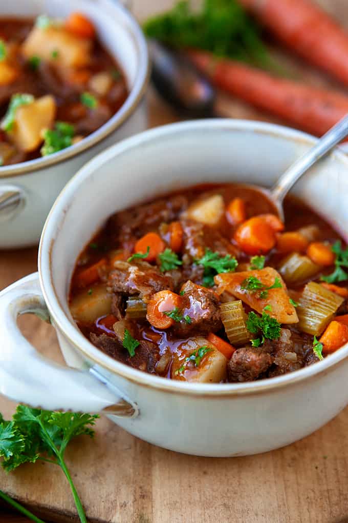 Instant Pot Beef Stew in a white soup bowl with a spoon. 