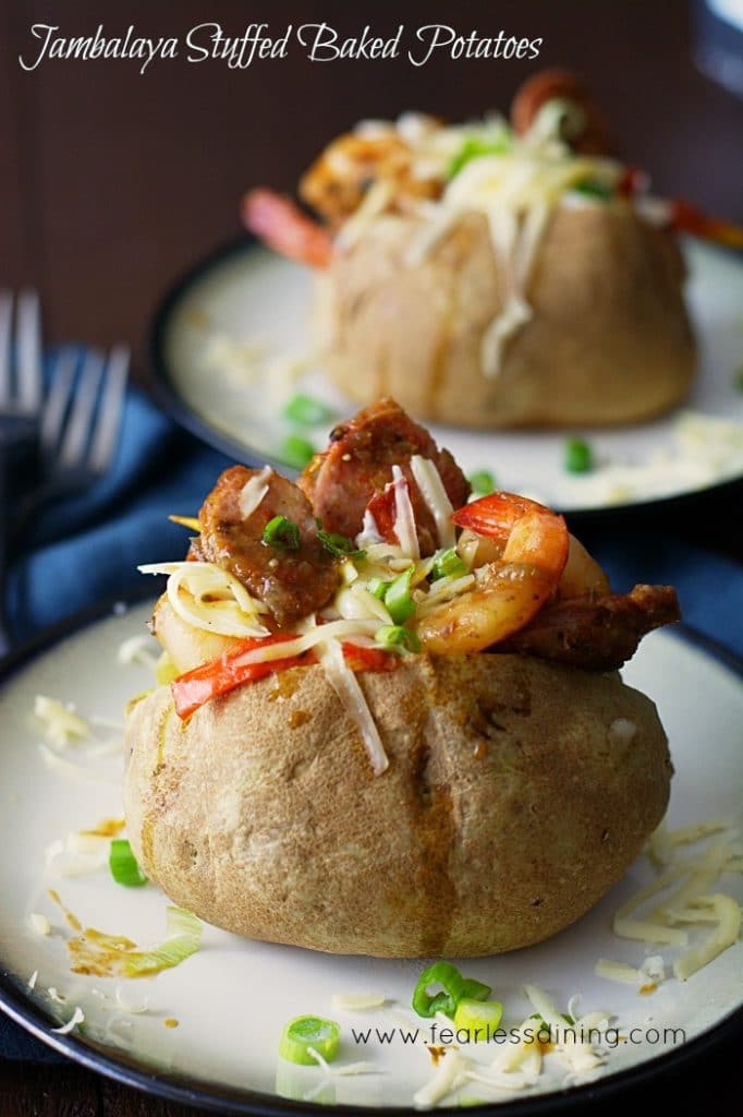 Mardi Gras Jambalaya Stuffed Baked Potato on a white and blue plate with chopped green onions