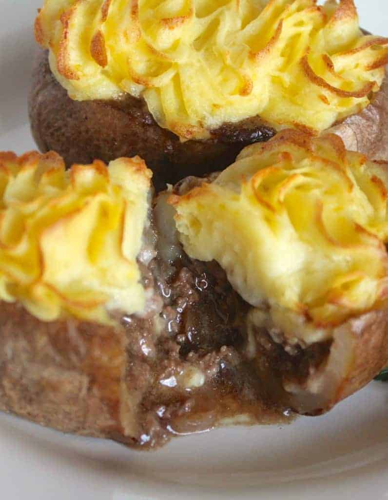 Individual Shepherd's Pies in Baked Potatoes cut in half and the griound beef so falling out