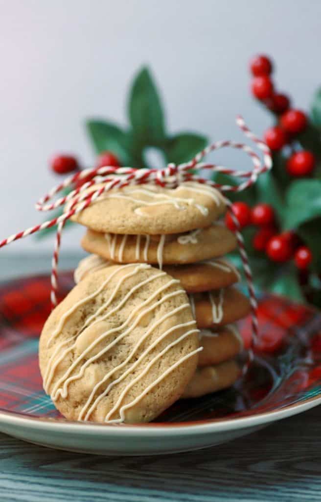 A stack of golden baked cookies tied with red and white twine with another cookie leaning on the stack.