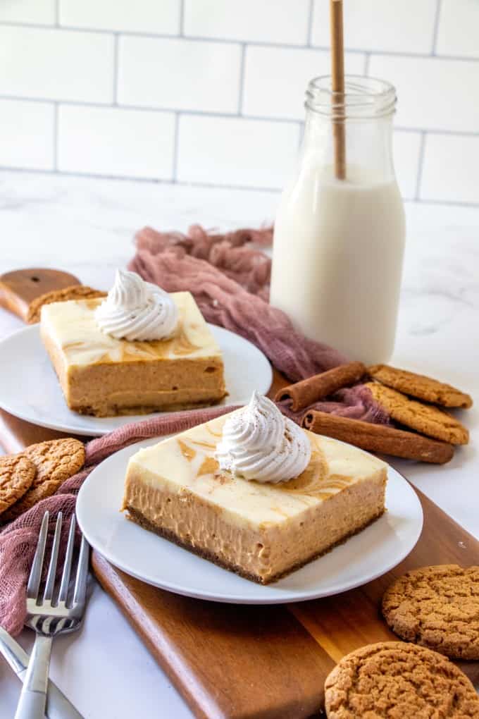 Whipped cream topped pumpkin cheesecake with a small bottle of milk. 