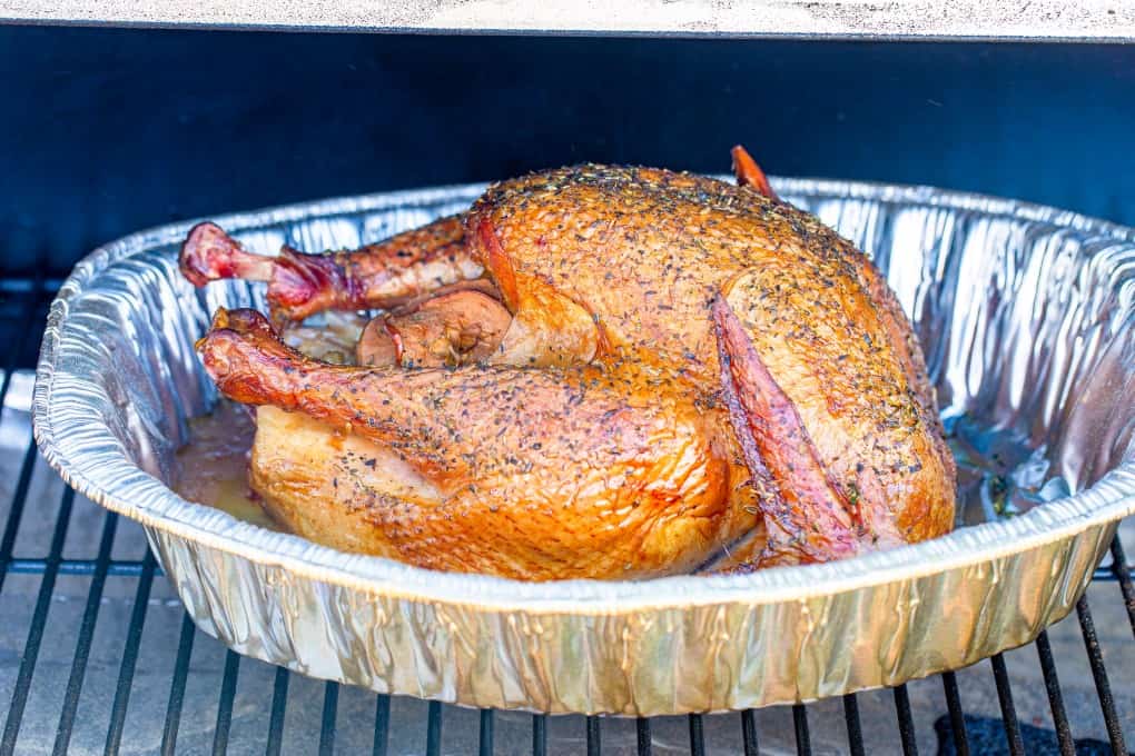 Turkey in a roasting pan in a smoker
