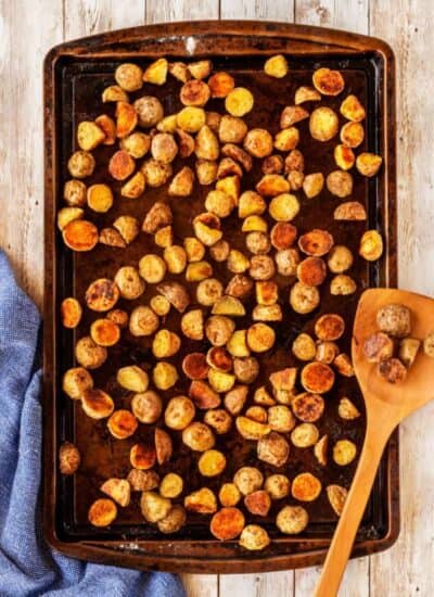 Extra Crispy Potatoes on a sheet pan with a wooden spoon.