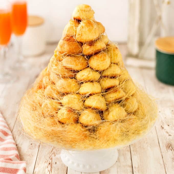 Square photo of a croquembouche on a cake stand. 