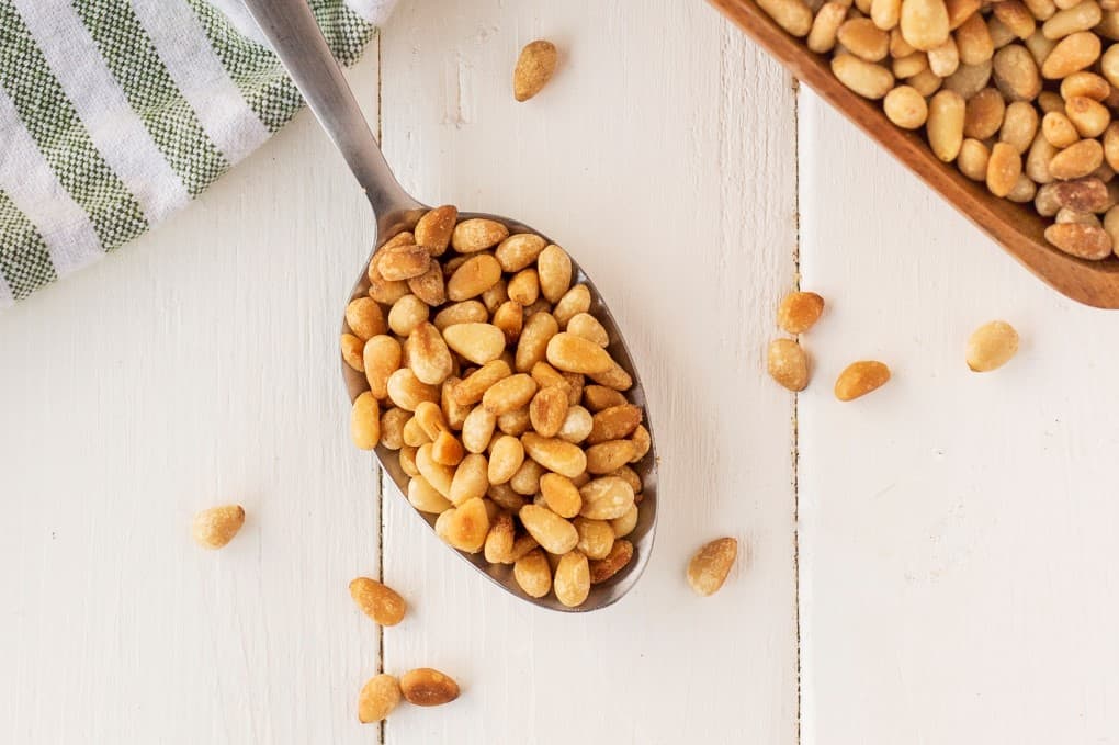 Toasted pine nuts on a spoon