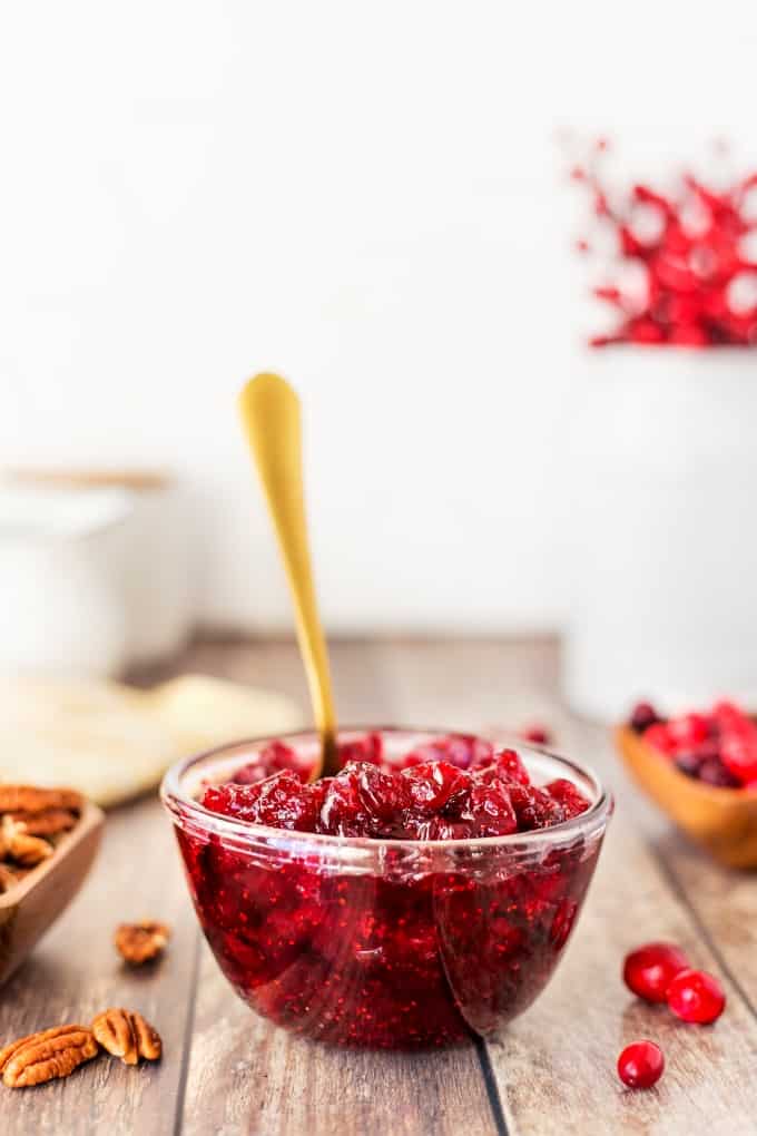 Cranberry sauce in a bowl with a spoon in it. 
