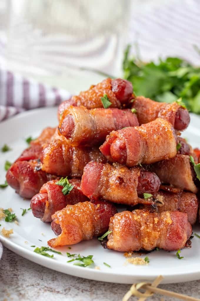 A plate full of bacon wrapped smokies. 
