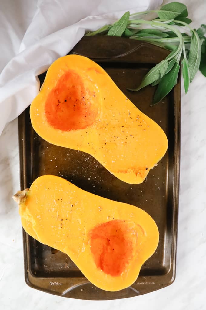 Halved squash on a baking sheet