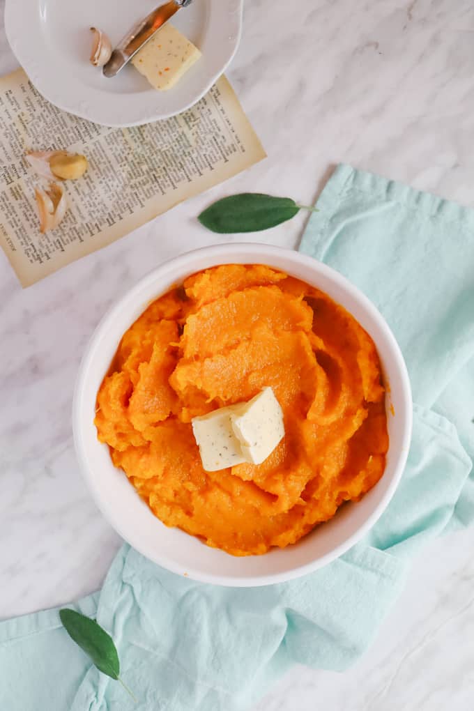 Overhead shot of mashed butternut squash in a casserole dish with butter