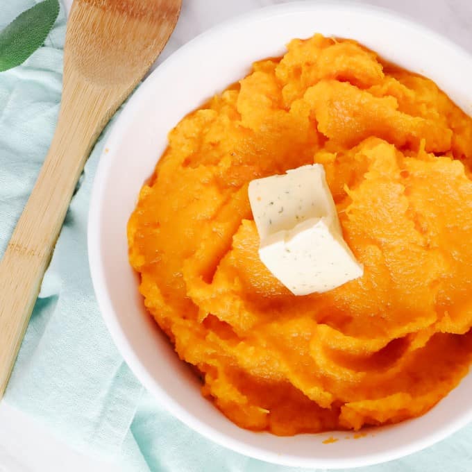 Overhead square picture of Roasted Mashed Butternut Squash in a casserole dish with butter.