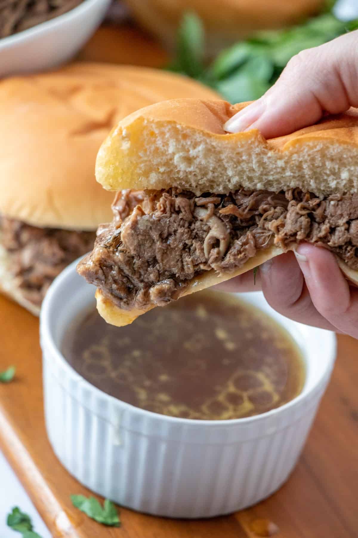 Beef dip sandwich dunked in au jus
