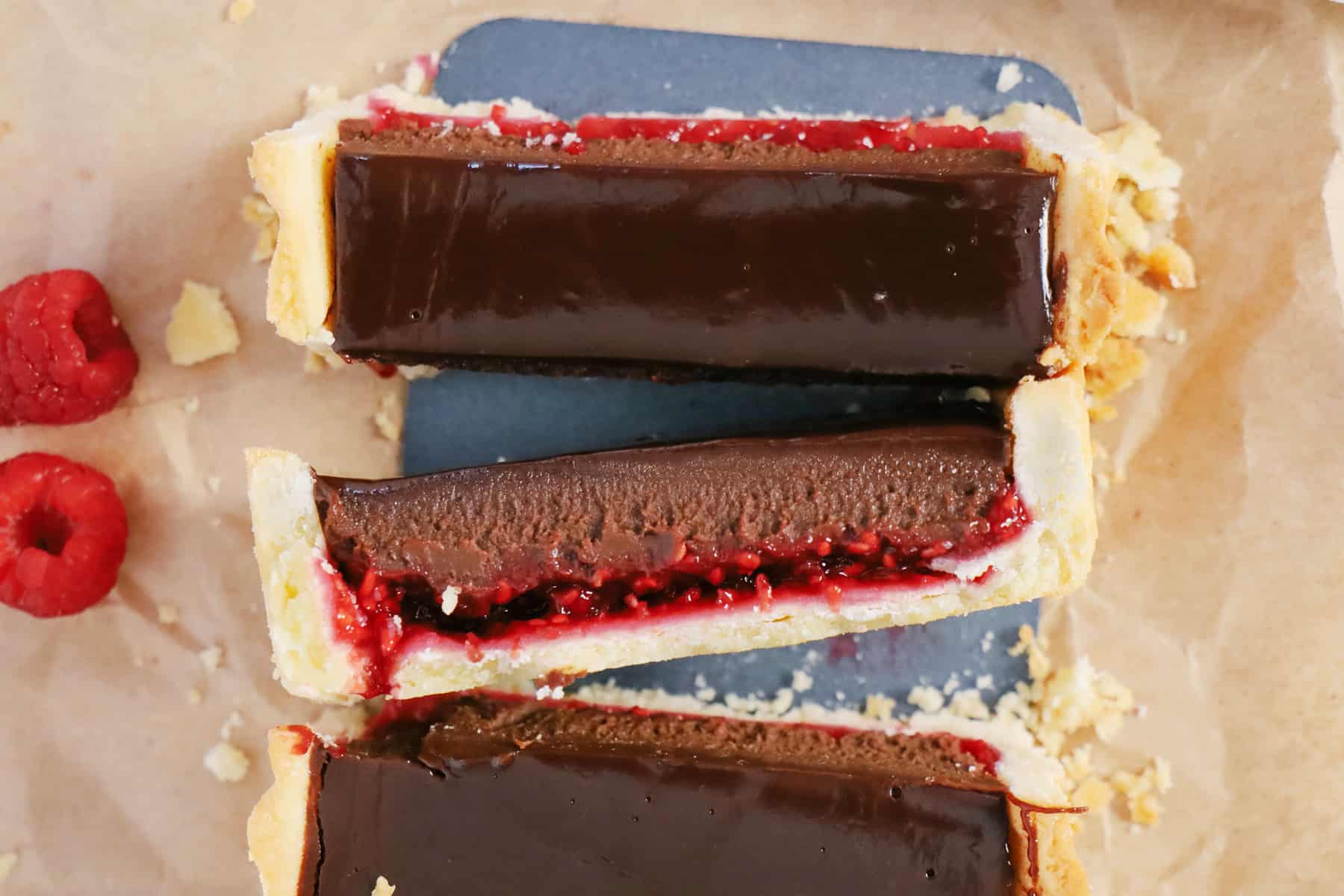 Overhead shot of sliced chocolate tart with raspberry jam