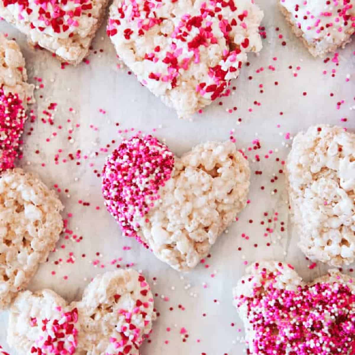 Square photo of heart shaped rice Krispie treats with sprinkles. 