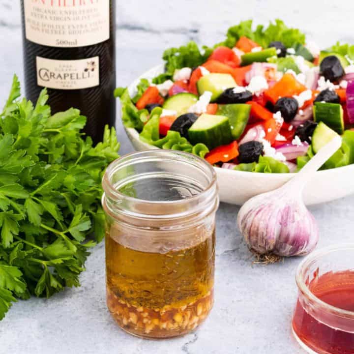 A salad surrounded by red wine dressing ingredients.