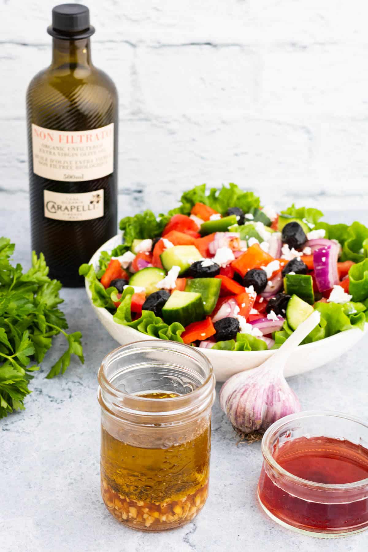 A salad surrounded by red wine dressing ingredients.