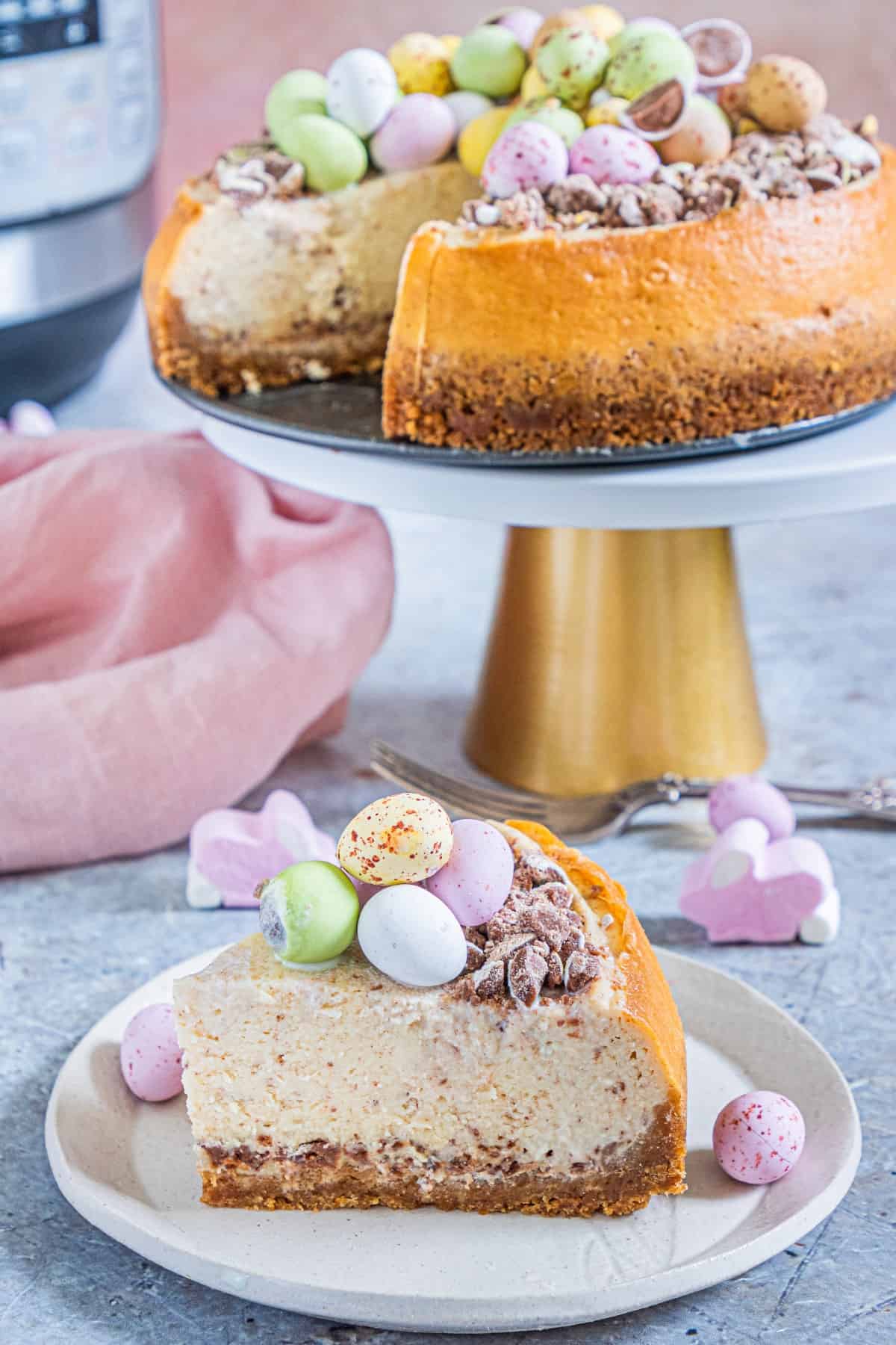 Easter Egg Instant Pot Cheesecake a slice and then a cheesecake on a stand