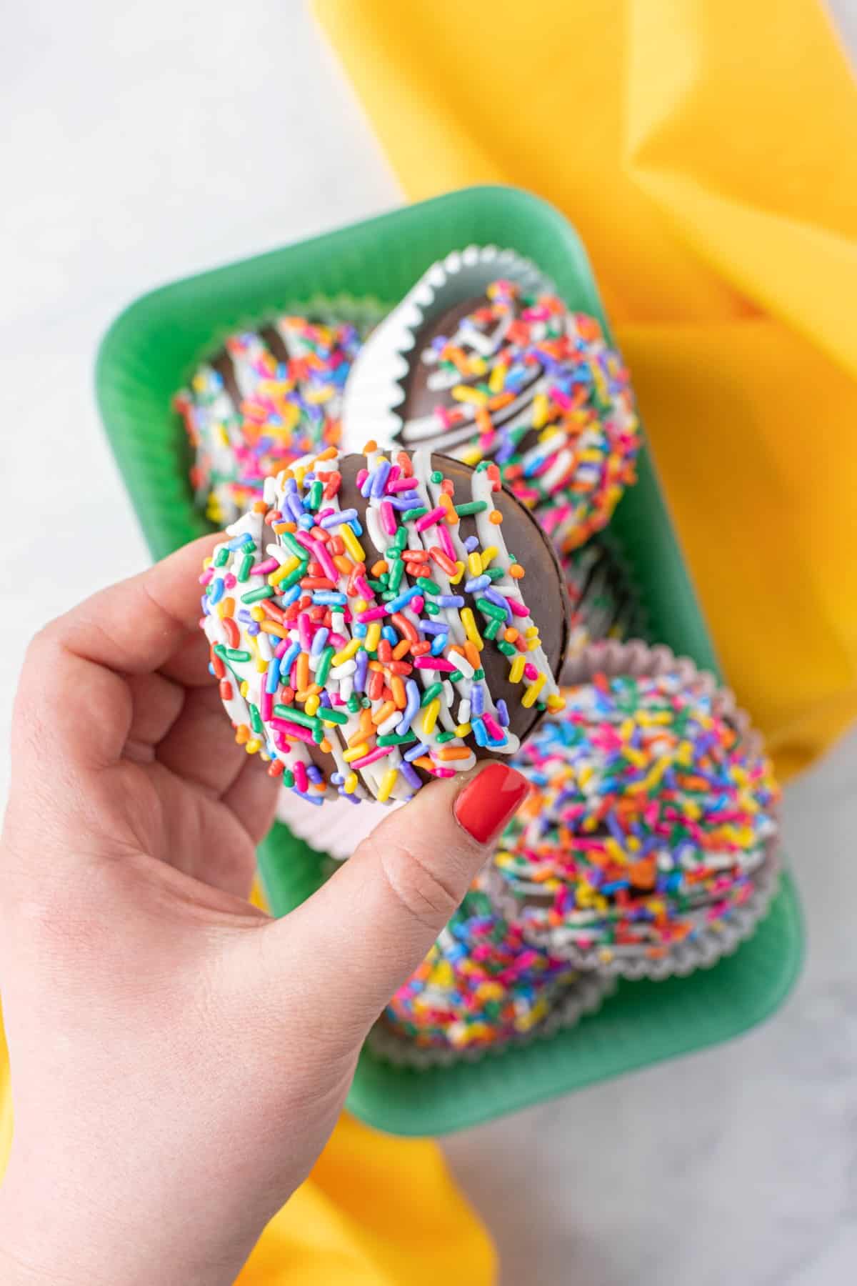 Funfetti Hot Chocolate Bombs, with one being picked up. 