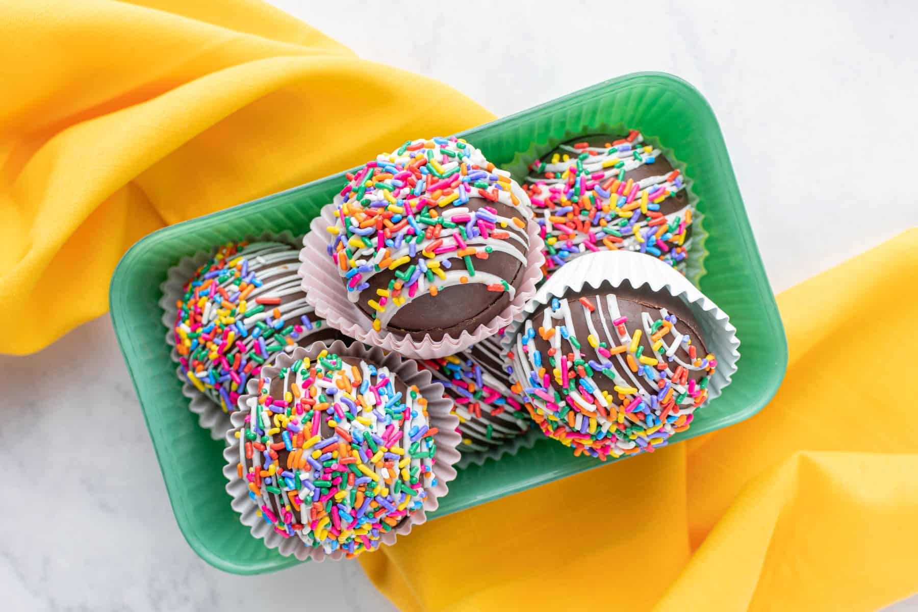 Horizontal photo and overhead of hot chocolate bombs in a green container