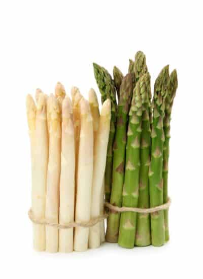 Two bunches of asparagus, one white and one green.