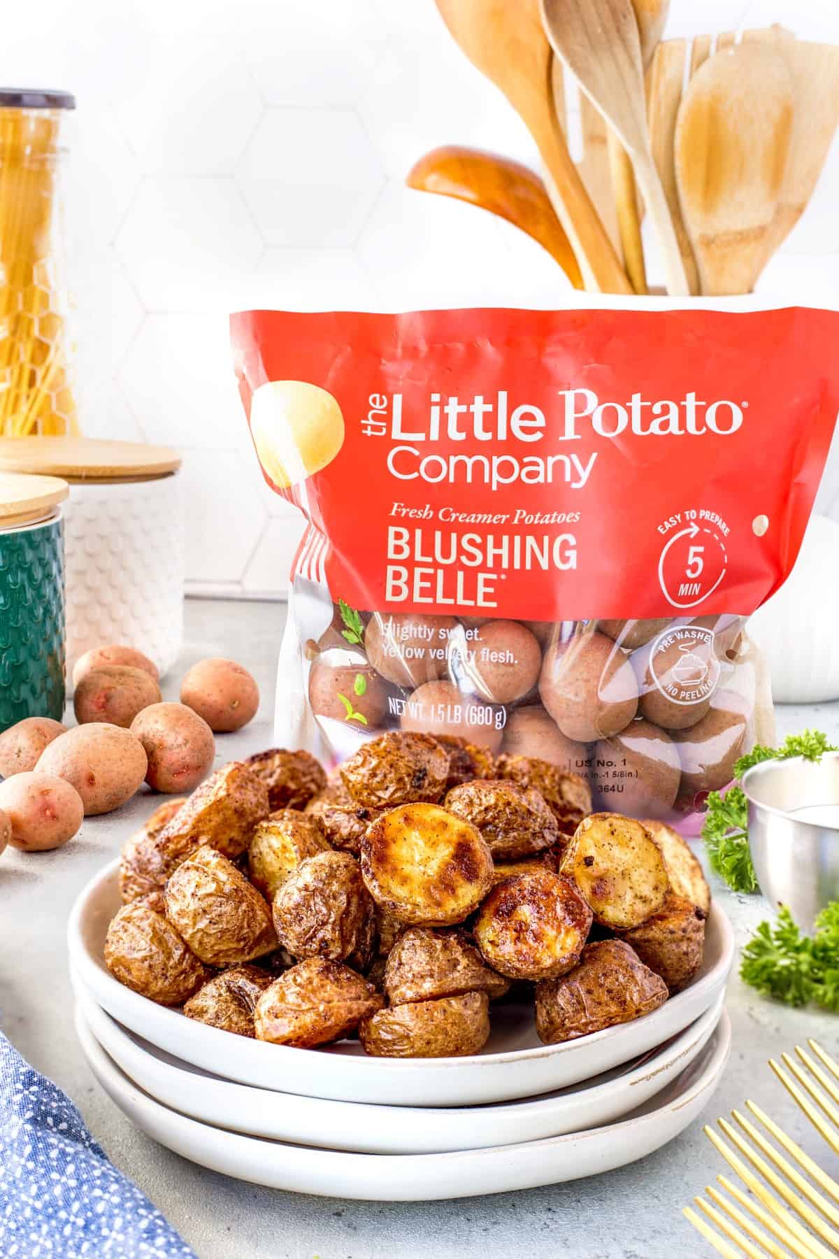 Plate of Cajun Roasted Potatoes with a Little Potato Company bag of potatoes in the background