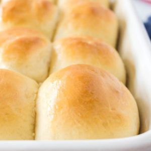 Close up shot of fluffy, soft sourdough buns in a baking pan.