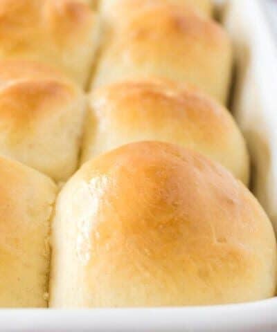 Close up shot of fluffy, soft sourdough buns in a baking pan.