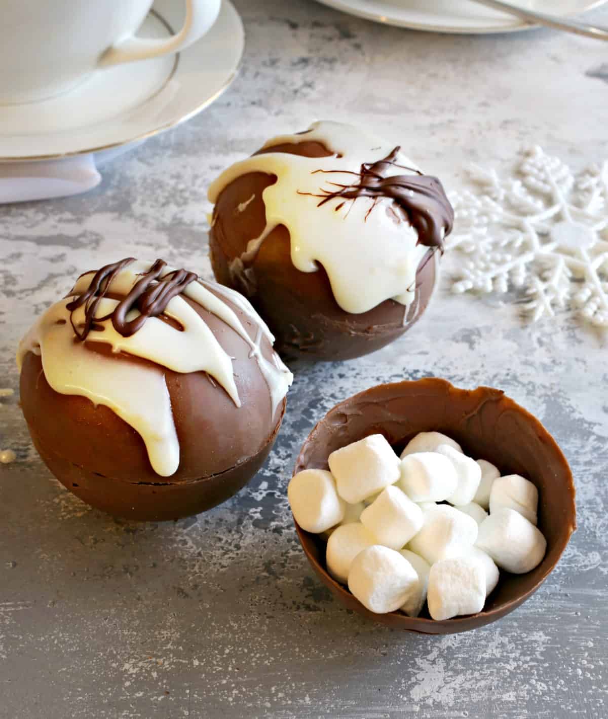 Original hot chocolate bombs, two full spheres and one half with mini marshmallows inside. 