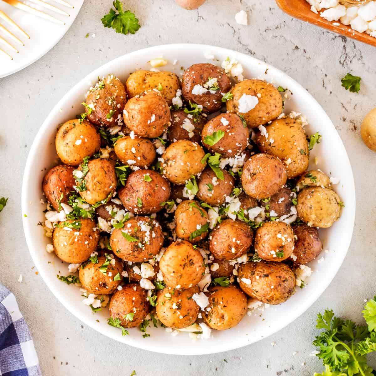 Square photo of Mediterranean potatoes in a bowl, overhead shot. 