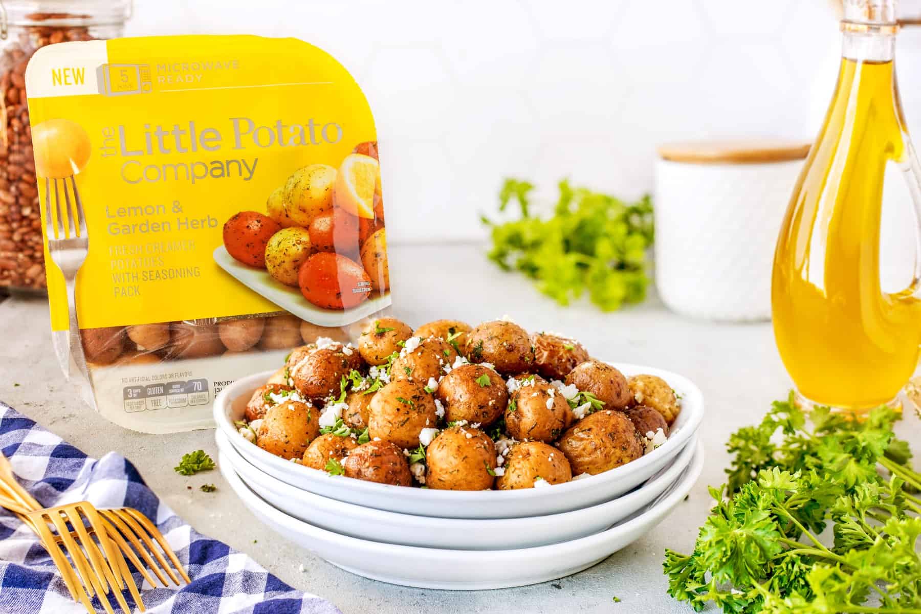 Horizontal of potatoes in a bowl with  the packaging from Little Potato Company in the background. 