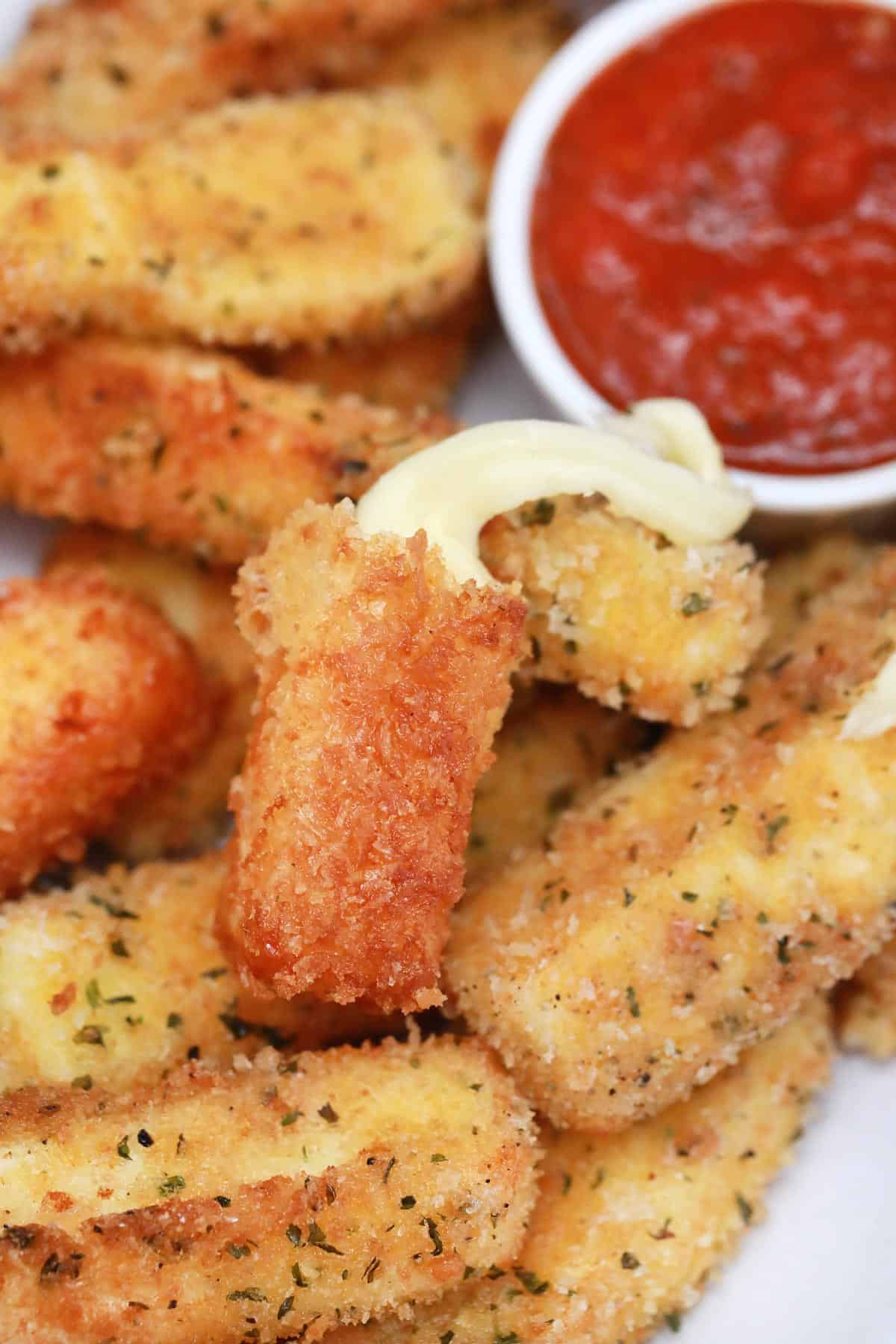 Plateful of cheese sticks and marinara dipping sauce.