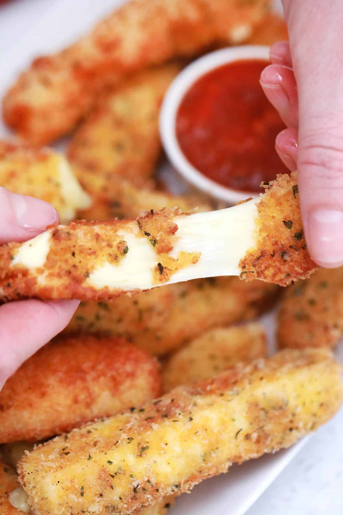 Pulling a fried cheese stick in half. 