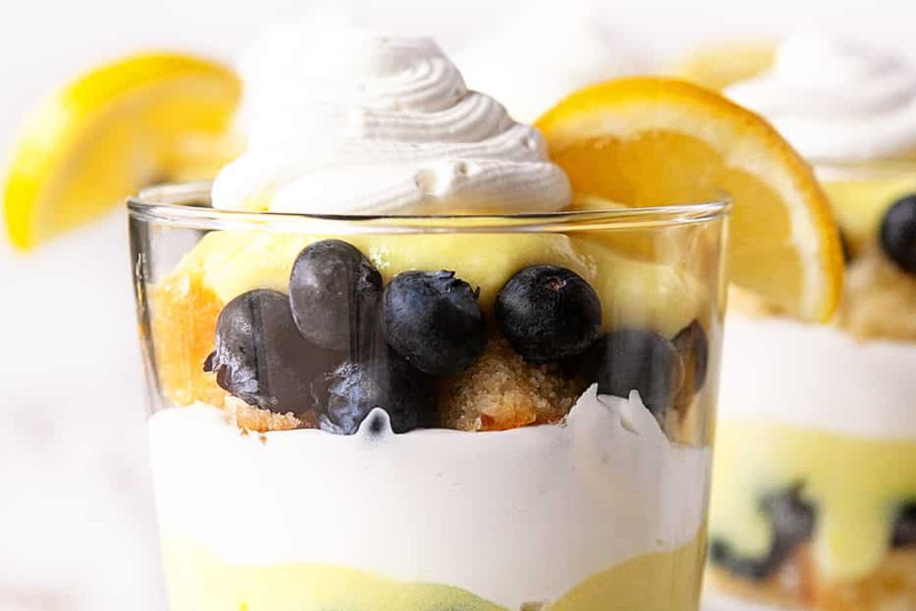 Lemon Blueberry Trifle is amazing for an incredibly easy dessert recipe for any occasion. It can be made in a large trifle bowl or individual dishes for a stunning dessert. Close-up of the trifle.