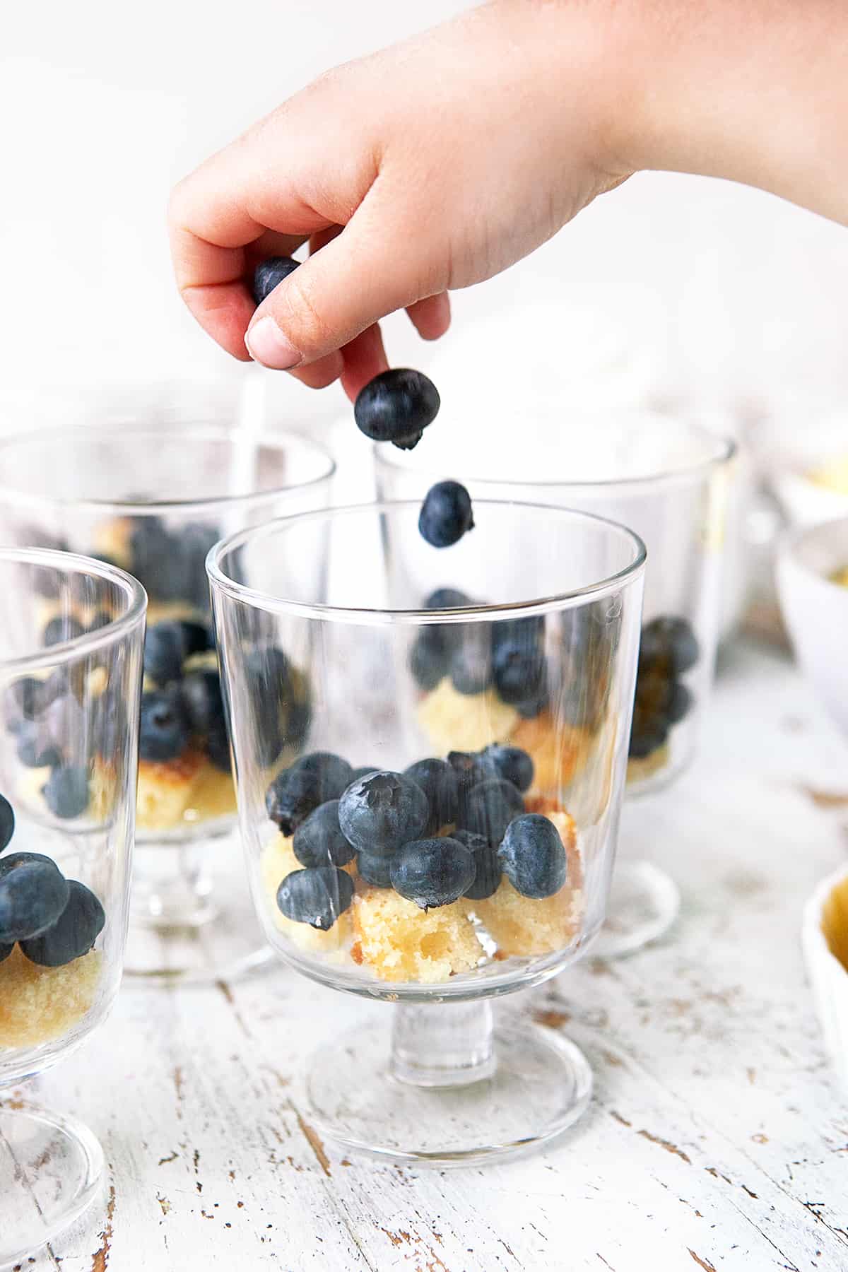 Tossing blueberries into a glass