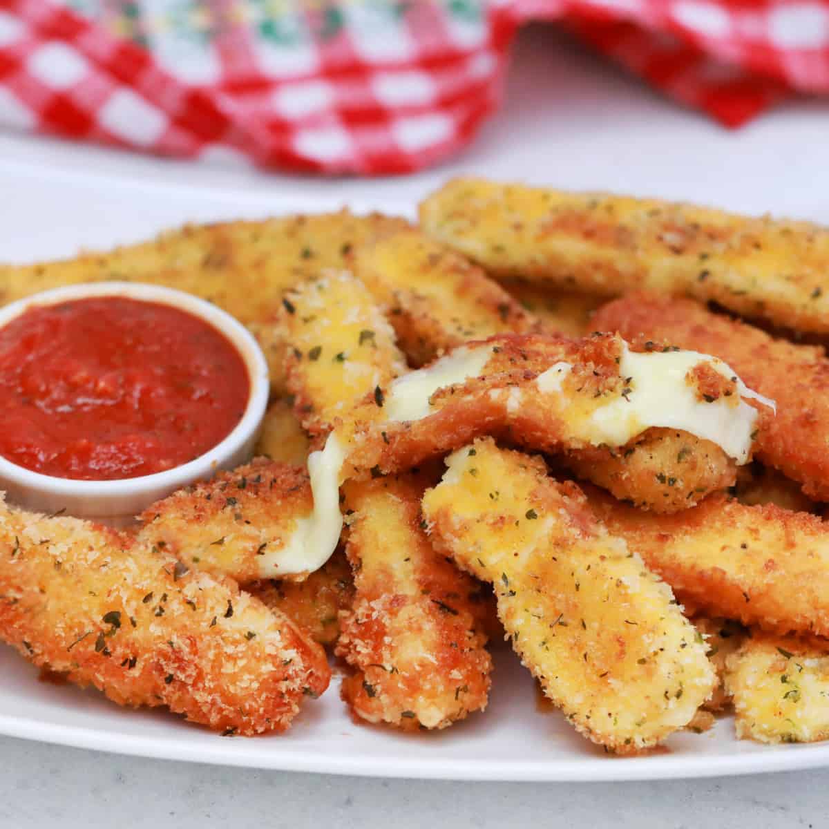 Square photo of a platter of mozzarella cheese sticks. 