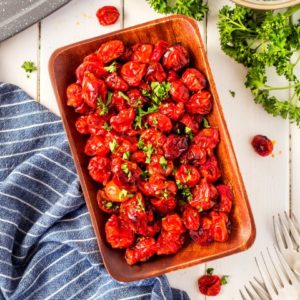 Overhead shot of roasted tomatoes in a wooden dish