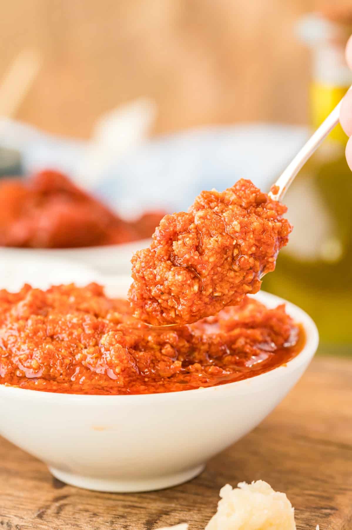 Spoonful of red pesto from a bowl