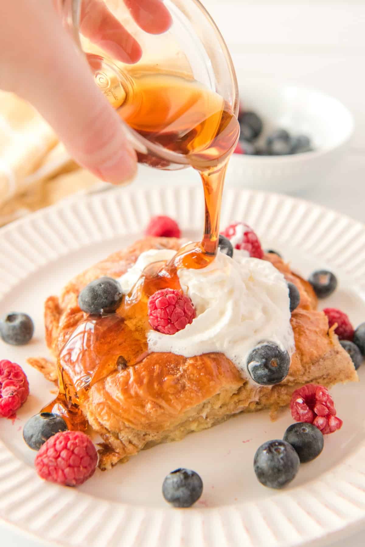 Pouring maple syrup on Croissant French Toast Bake
