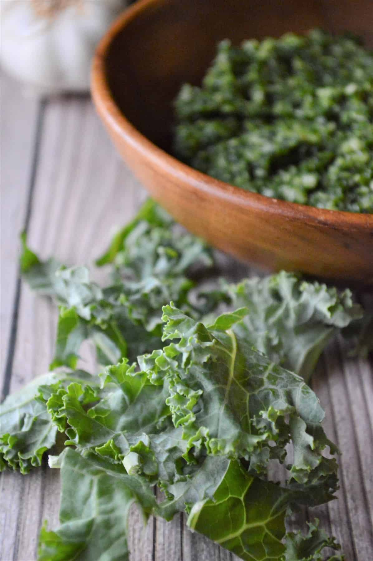 Kale in the forefront and a bowl of pesto in the back